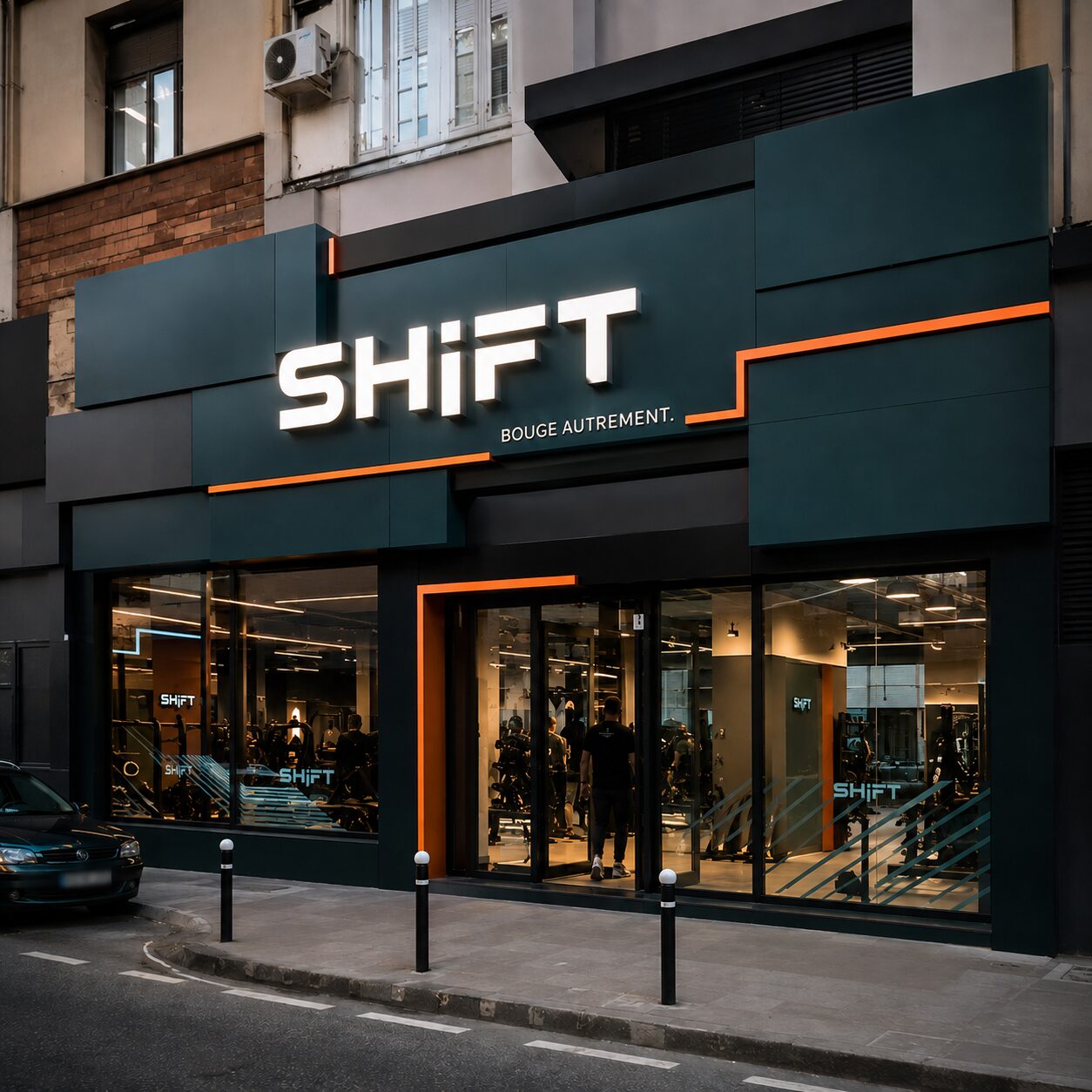 Façade en cassettes composite vert foncé avec liserés orange pour la salle de sport Shift, montage en décalé
